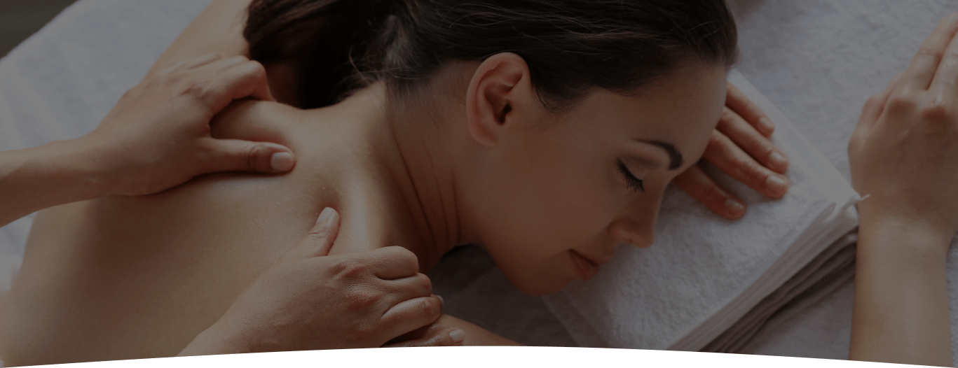 A woman lying down and having her back Massage therapy in a spa center